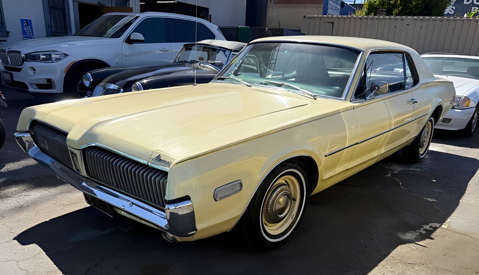 Vintage yellow classic car parked outside.