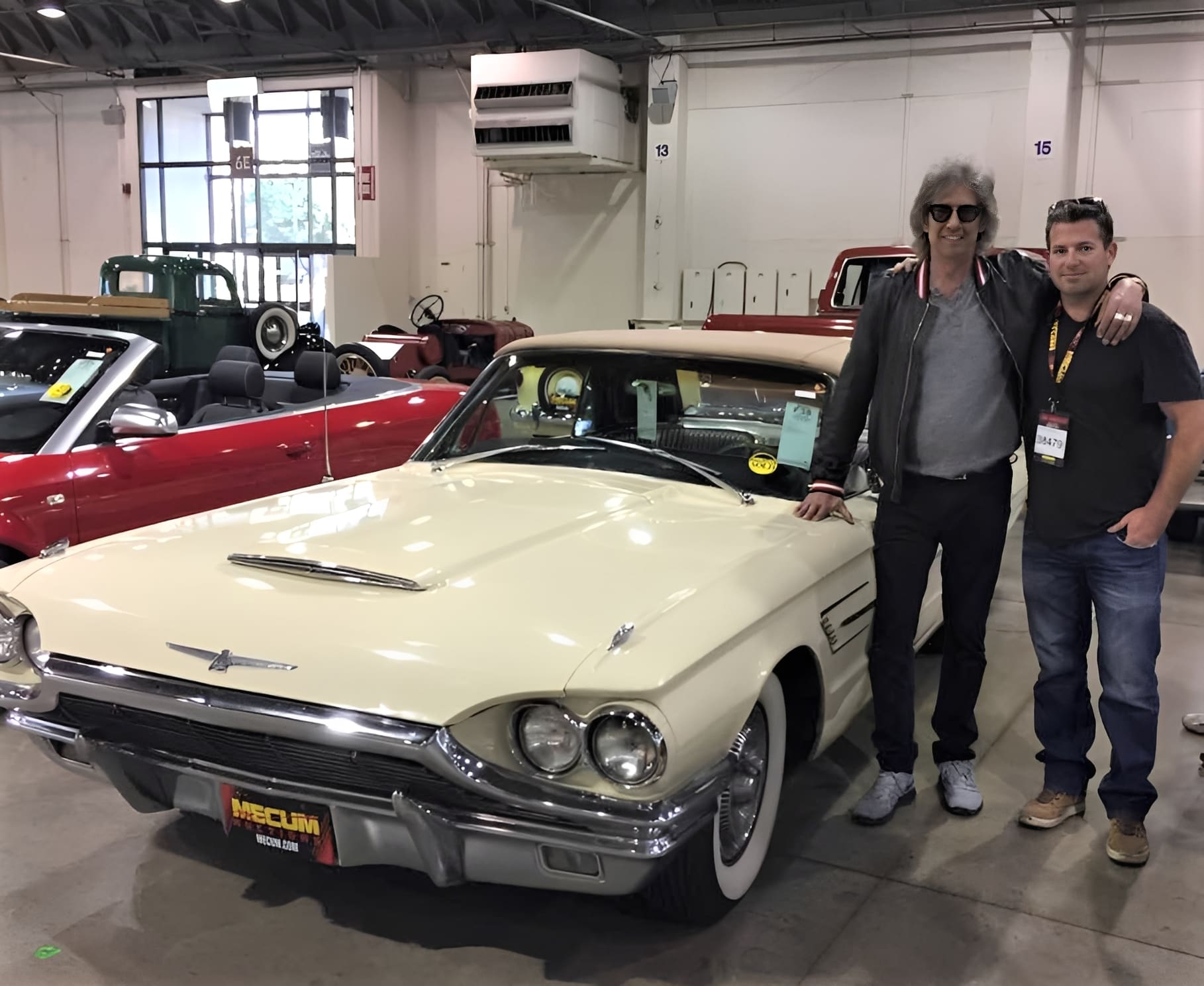 Two people posing with vintage white car.