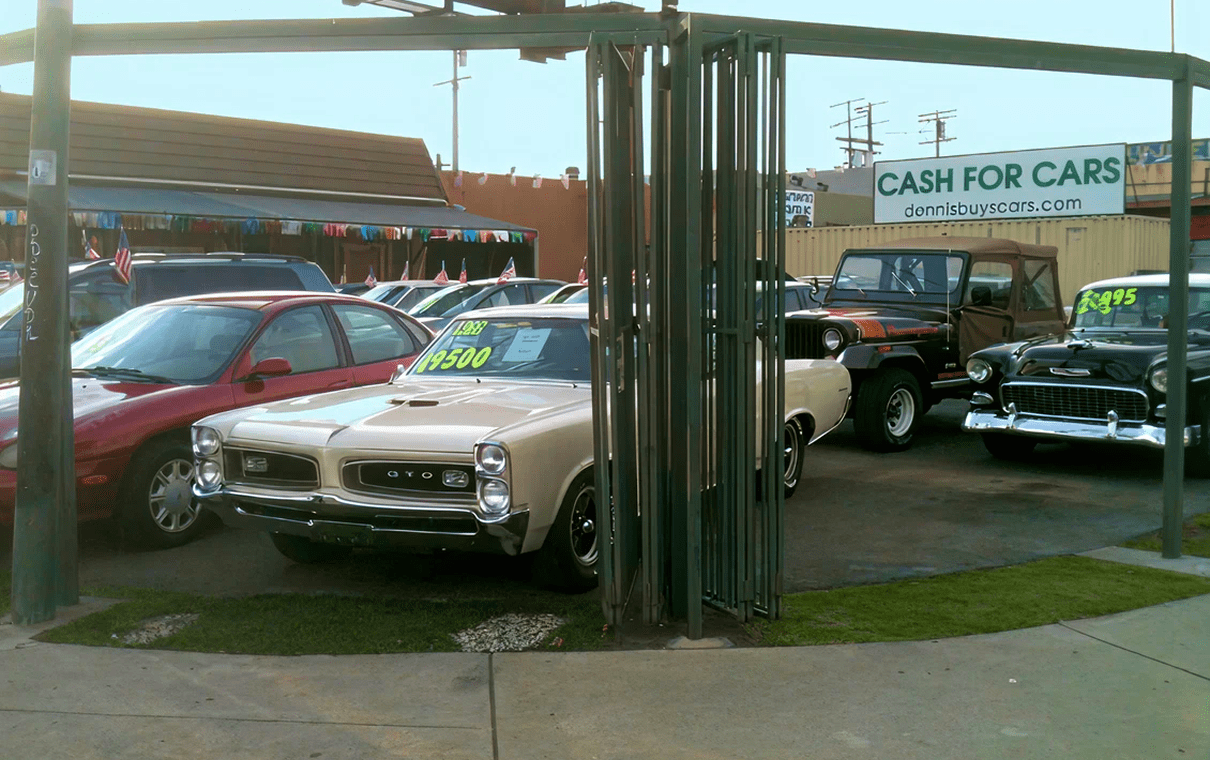 Used cars displayed at dealership with prices.