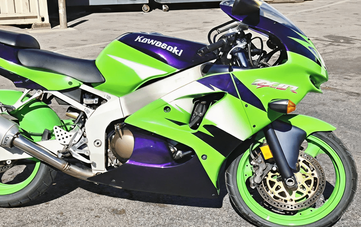 Green and purple Kawasaki sport motorcycle parked.