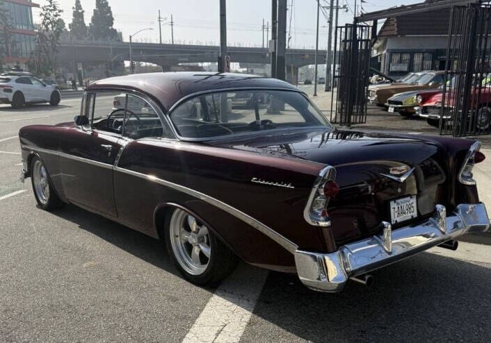 Classic maroon car parked on street corner.