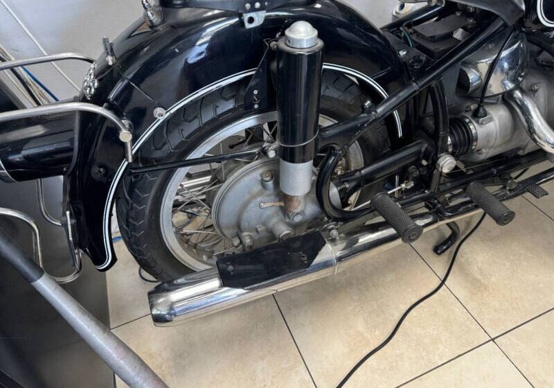 Vintage motorcycle rear wheel and exhaust system.