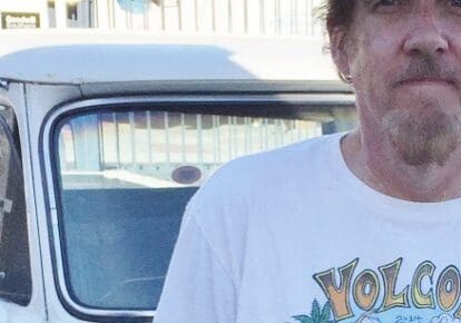 Man standing in front of vintage car.