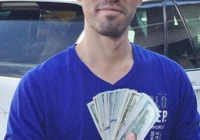 Man holding a stack of dollar bills.